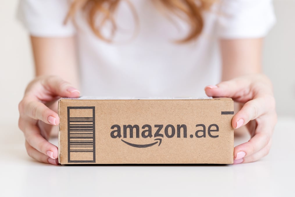 Woman holding delivered goods in cardboard box